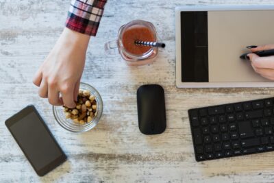 فردی در حال دورکاری و مصرف اسنک‌های کوچک،